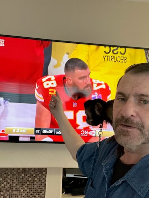 Sara perched on Allen's shoulder watching football at home